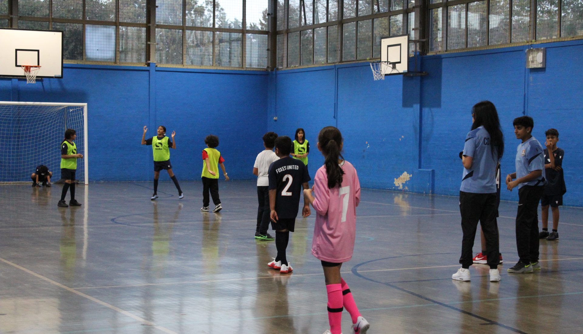 Kids playing football in a hall